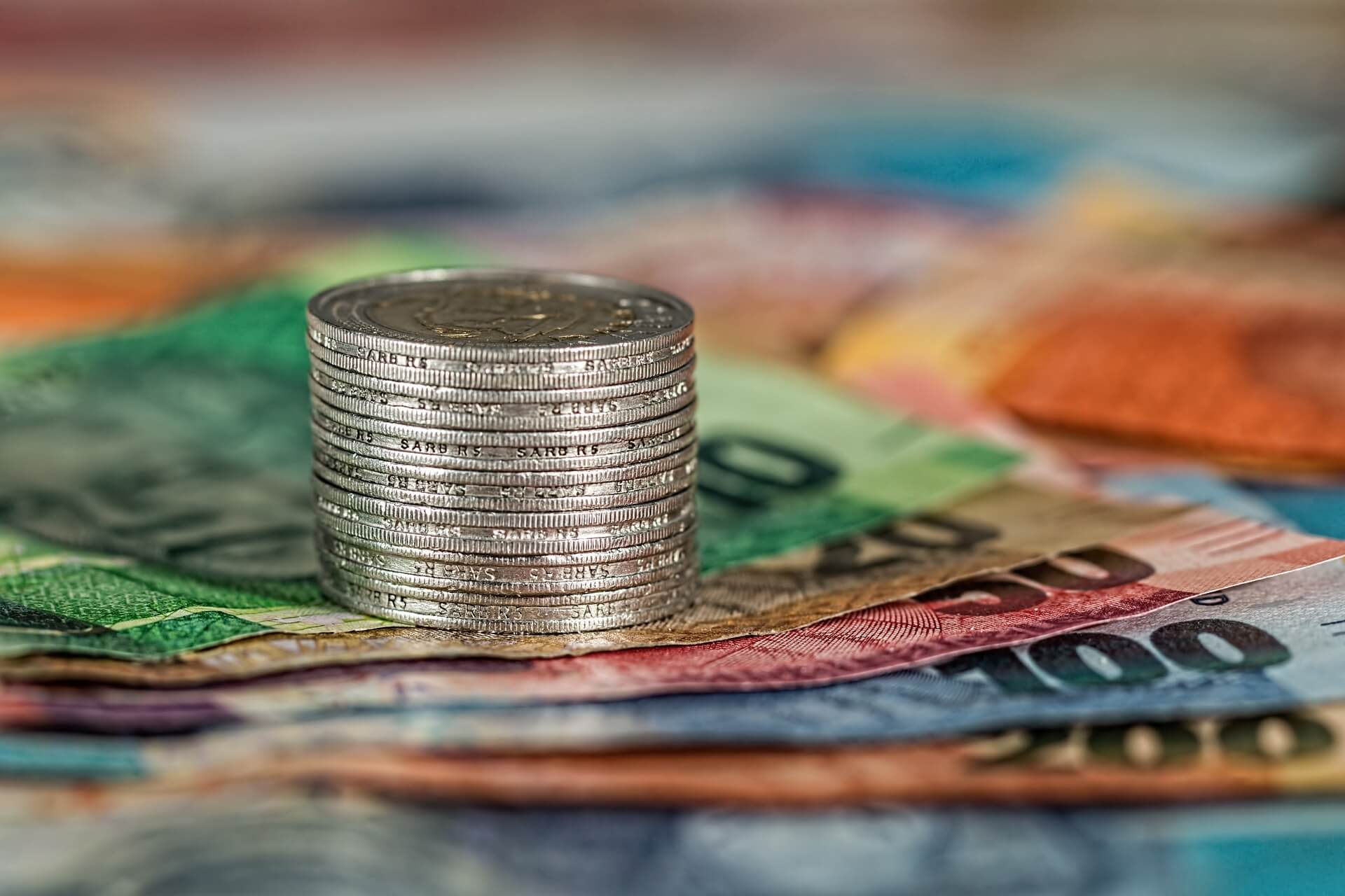 Coins stacked on top of notes, symbolizing financial support and opportunities for students, with Shule Moja focusing on helping students secure scholarship opportunities.